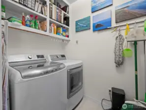 Walk down the hall and you find the laundry room. More shelving on the opposite side. Washer and dryer will stay.
