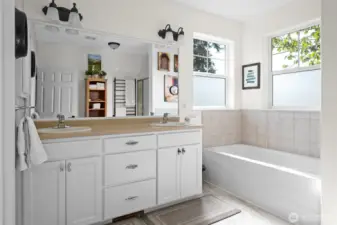 The Primary bathroom; features a water closet to the left,(door not seen)  double sinks , soaking tub and a walk-in shower.