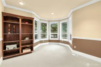 Elegant main-floor den or private office with custom built-ins and expansive windows that fill the space with natural light.