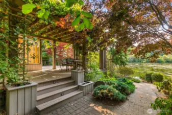 The composite deck wraps around the sunroom area with paved pathways curving through the area at the back of the home.