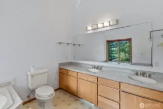 Large primary bathroom with dual sink vanity and jetted soaking tub.