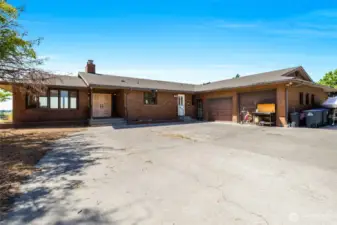This brick home has five bedrooms and three bathrooms. There are three front entrances, one double door, and two single doors, as well as two garage doors, one a couple of feet taller than the other. This is the main garage.