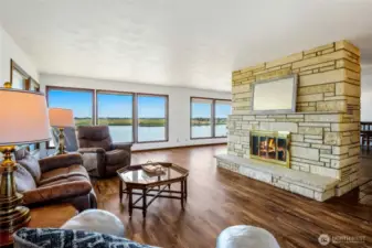 From this corner of the living room, you can see the amazing lake views, and to the right is the double French doors and hallway to the kitchen and dining room. There is another fireplace on the bottom floor.
