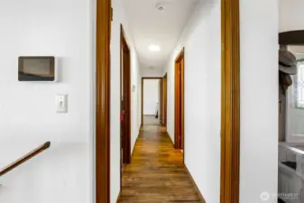 Hallways to the main floor bedrooms, bathrooms, utility room, and garage access.