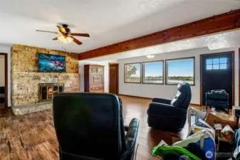 Behind the fireplace are two bedrooms with doors to the right and to the left of it, and there are connecting doors between the third and fourth bedrooms.  To the left of the photo is the kitchen, and behind you is the hall down to the fifth bedroom and garage.