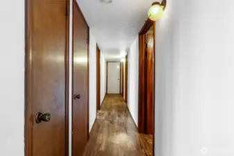 This hallway on the lower level leads to the 5th bathroom of the whole house, a large storage room, the walk-in pantry, and do you see that door at the end of the hallway? That's the lower level garage which will fit a small car or a couple of motorcycles. You can also use it as a storage room.