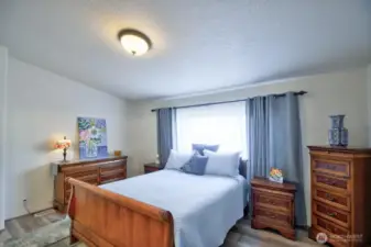 Spacious primary bedroom with vinyl plank flooring and special blackout window blinds.