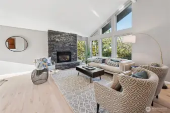 Living Room features floor-to-ceiling stacked stone with gar fireplace, vaulted beamed ceiling with wall of windows looking out on the northwestern territorial views.