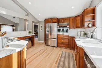 The Chef's kitchen has abundant cabinets, stainless steel appliances including built in oven, gas cooktop, dishwasher and 3 door refrigerator. Quartz countertops and backsplash with undermount double basin sink with garden window overlooking back deck.