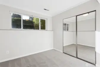 Downstairs 3rd bedroom has large window looking out on the south planting area of the yard. It also has mirrored closet doors.