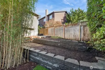Planting beds on east side of back yard. Path around the beds leads to side access to front yard.