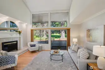 Formal living room with floor to ceiling windows, gas fireplace with tile surround and ornate wood detailing