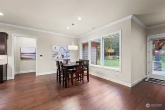 Informal dining area adjacent to the kitchen, large windows bring the outside in.