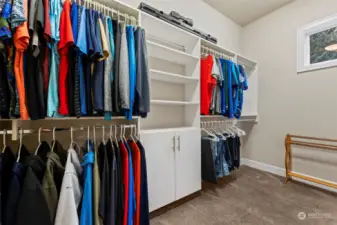 Large primary walk-in closet, thoughtfully designed with abundant shelving and a window that fills the space with natural light.