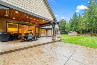 The backyard features a covered porch, thoughtfully designed with recessed lighting, an outdoor fan, and heaters for year-round comfort.