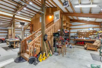 Inside the shop there is ample light and insulation.  Building has its own 200 amp service, three roll up doors, one 14 feet tall.  Up the stairs is the guest room.