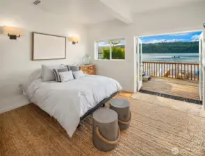 Large flex room downstairs currently used as sleeping quarters with bunk and queen bed with french doors to lower deck with hot tub