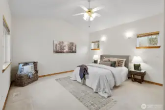 Primary bedroom with ceiling fan and attached bathroom.