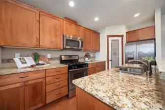 The quality of the construction is evident, with granite counters, stainless appliances and beautiful wood cabinetry. Enjoy gas cooking, with a built in microwave and tile backsplash.