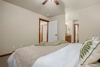 Alternate view of the primary bedroom, with access into the hallway on the left, vanity, walk in closet & water closet to the right.