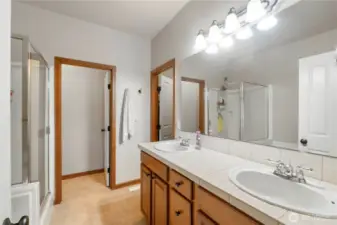 Primary  bathroom. Notice double sinks and high countertops. Full bathroom. And walk in closet.