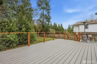 Oversized Trex deck offering plenty of space for outdoor dining, entertaining, and relaxing, all overlooking a private backyard.