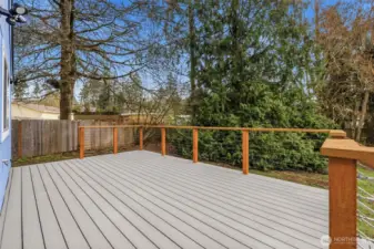 Spacious deck overlooking a peaceful, tree-lined backyard that offers added privacy and a natural setting.
