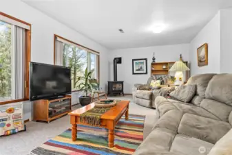 Daylight basement -Family room with kitchenette and large picture windows that look out to nature and the creek.  Cozy gas stove makes this space perfect to unwind! It is also a great space to have guests stay or rent out! Access door to covered patio.