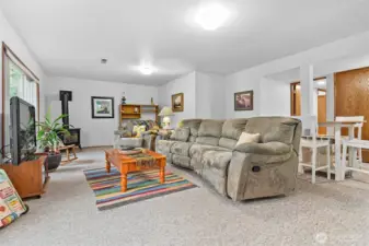 Daylight basement -Family room with kitchenette and large picture windows that look out to nature and the creek.  Cozy gas stove makes this space perfect to unwind! It is also a great space to have guests stay or rent out! Access door to covered patio.