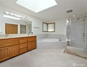 Brand new deep soaking tub and glass shower in primary suite bathroom