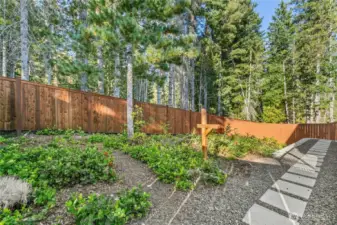 Completely fenced backyard is great for pets! Native vegetation is easy to maintain. Steps lead around both sides of the home.