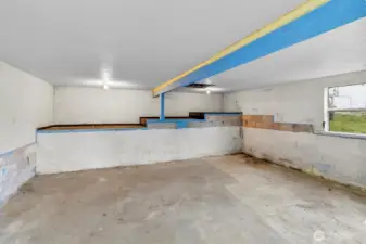 Large open room only accessible from the outside back of the home featuring concrete floors and tall ceilings for you to bring your imagination.