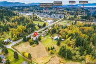 Aerial showing the property’s location amidst natural greenery and Hwy.