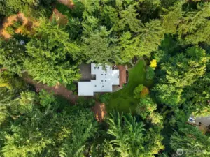 An Aerial View featuring the mix of garden space, forest and level lawn.
