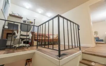 view heading up the stairs looking into the open den/office