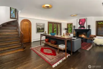 Coved barrel ceilings lit up, original curved mahogany trim, leaded glass windows and a blackened steel fireplace.