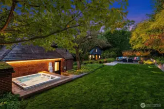 Hot tub tucked behind the garage and a flat grassy area for Fido, croquet, kid play