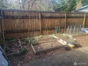 Patio off of the living room is fully fenced with garden beds.