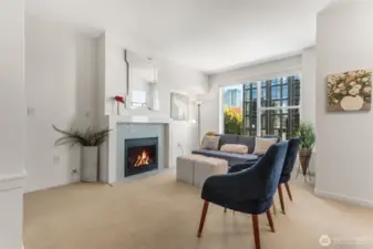 Bright and inviting—this spacious living room features a sleek tile-surround gas fireplace and floods with natural light in this top-floor, penthouse-style unit.
