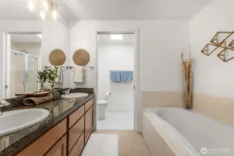 Spacious primary ensuite featuring a relaxing soaking tub, dual sinks, and refreshed vanity lighting for a bright, modern feel.