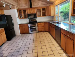 Large kitchen with granite counter and tile floor.