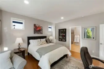 Primary bedroom with room for desk and storage along with King size bed and chase lounge