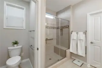 Primary bathroom with walk in shower, separate water closet with grab bars already installed.