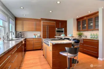 A large 4-burner gas stove, an oversized refrigerator, a wall oven with a microwave convection oven above, and a warming drawer add function to the fashion of this amazing kitchen.
