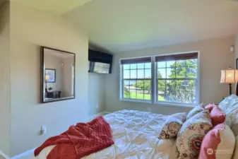 You may want to stay in bed a little longer and enjoy the water views from this primary suite with vaulted ceilings.