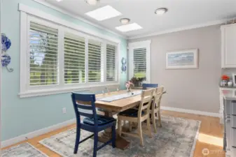 Light filled informal dining space with skylights and large windows overlooking the backyard and golf course.