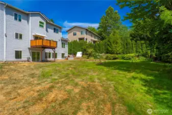 Large gently sloping backyard adjacent to green space providing privacy