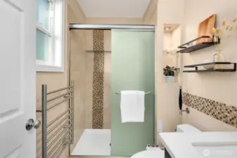Remodeled primary bathroom with heated floors and towel warmer