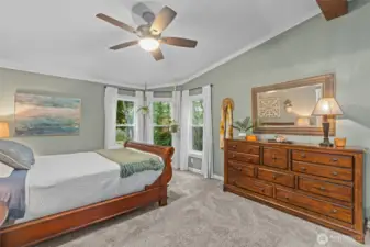 Primary bedroom suite with large bay windows.