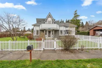 Charming Montesano farmhouse with white picket fence, wide streets, and sidewalks—situated on a spacious double corner lot in a quiet Grays Harbor neighborhood.